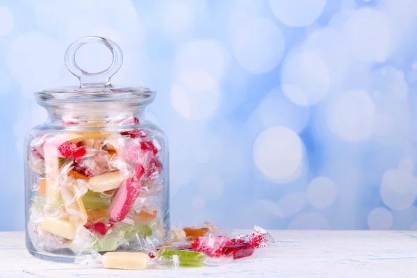 Caramelle saporite in vaso sul tavolo su sfondo luminoso — Foto Stock