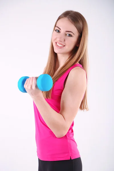 Giovane bella ragazza fitness che si esercita con i manubri in palestra — Foto Stock