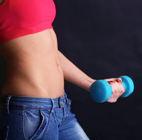 Young beautiful fitness girl exercising with dumbbells, close-up, isolated on black — Stock Photo, Image