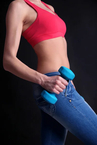 Young beautiful fitness girl exercising with dumbbells, close-up, isolated on black — Stock Photo, Image
