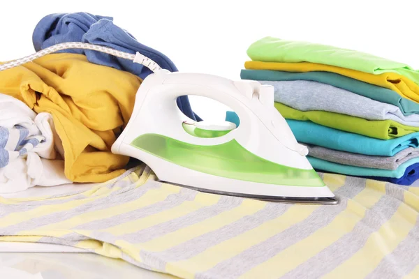 Iron and pile of colorful clothes close up — Stock Photo, Image