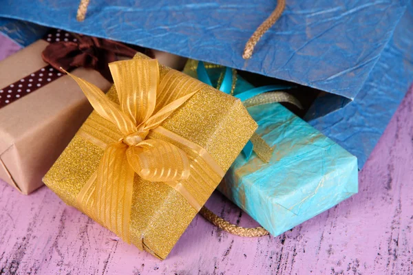 Presents with paper bag on wooden background — Stock Photo, Image