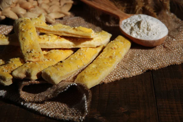 Bread sticks on sackcloth on wooden background — Stock Photo, Image