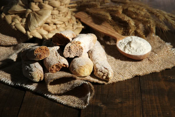 Palitos de pan sobre tela de saco sobre fondo de madera — Foto de Stock