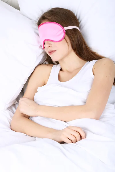 Jovem bela mulher dormindo na cama com máscara de olho close-up — Fotografia de Stock