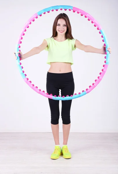 Mujer haciendo ejercicios con hula hoop en la habitación — Foto de Stock