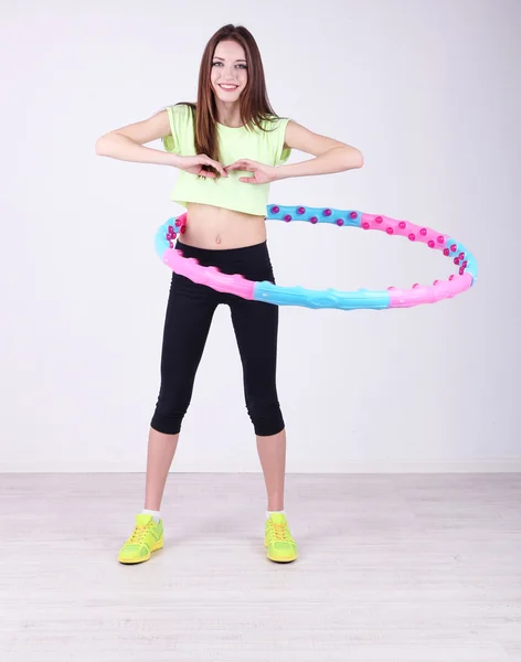 Woman doing exercises with hula hoop in room — Stock Photo, Image
