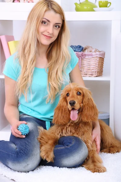 Beautiful young woman with cocker spaniel in room — Stock Photo, Image
