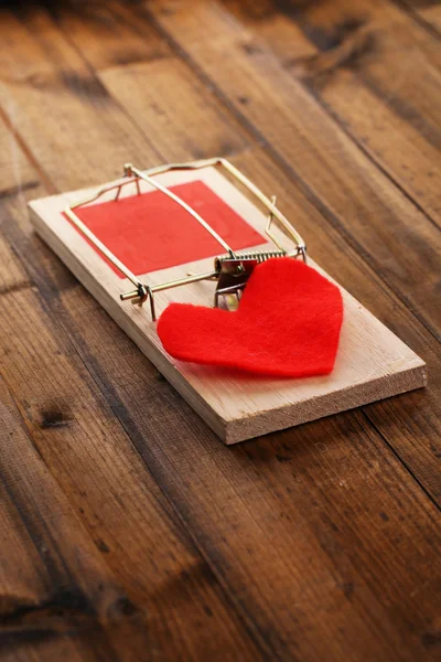 Mousetrap with heart on wooden background — Stock Photo, Image
