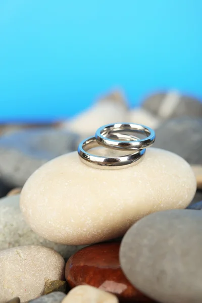 Свадебные кольца на скалах на синем фоне — стоковое фото
