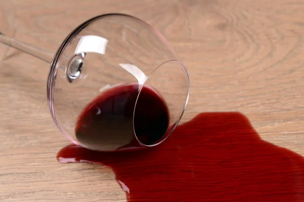 Перевернутый бокал вина на полу крупным планом — стоковое фото