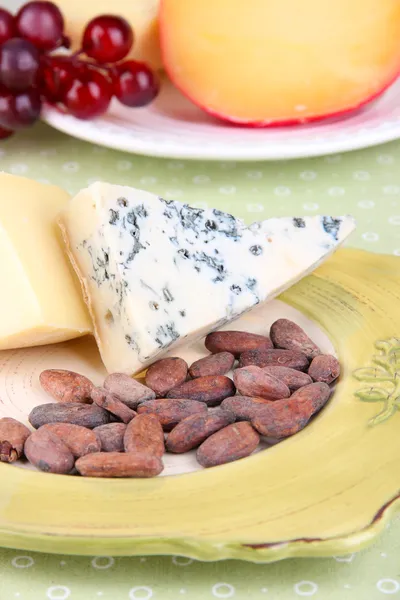 Piatto di formaggio assortito, uva, bastoncini di pane. sul tavolo, su fondo chiaro — Foto Stock