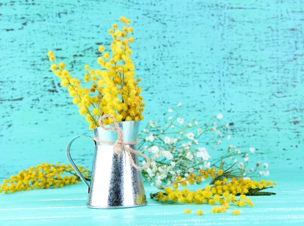 Galhos de flores mimosa em vaso na mesa de madeira azul — Fotografia de Stock