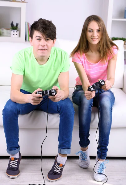 Menina e menino jogando jogos de vídeo em casa — Fotografia de Stock