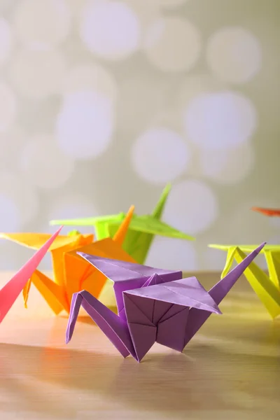 Grúas de origami sobre mesa de madera, sobre fondo claro — Foto de Stock