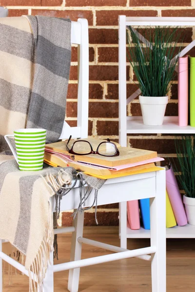 Összetétele a szemüveg és a könyvek, szék, szekrény és a fal háttér — Stock Fotó