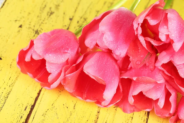 Pink tulips on wooden table — Stock Photo, Image