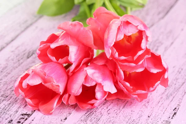 Roze tulpen op houten tafel — Stockfoto