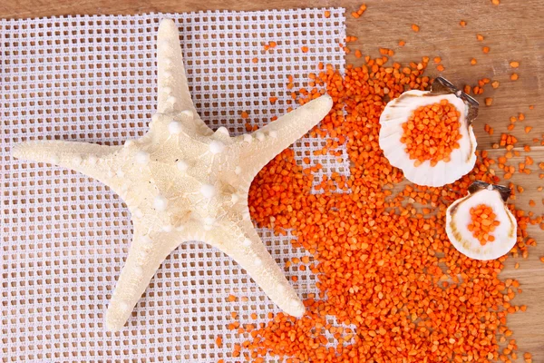 Cristaux de sel de mer avec coquillages de mer, étoile de poisson sur fond en bois de couleur — Photo