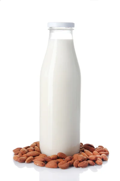 Γάλα αμυγδάλων σε μπουκάλι με αμύγδαλα, που απομονώνονται σε λευκό — Φωτογραφία Αρχείου