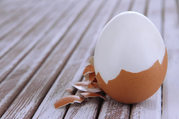 Очищенное яйцо на деревянном фоне — стоковое фото