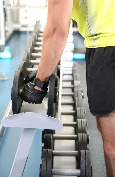 Kerl mit Hanteln auf Fitness-Hintergrund Nahaufnahme — Stockfoto