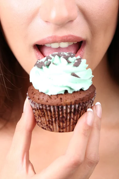 Primer plano de la mujer comiendo cupcake de chocolate — Foto de Stock