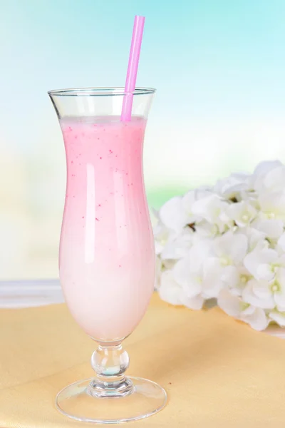 Milchshake auf dem Tisch auf hellblauem Hintergrund — Stockfoto