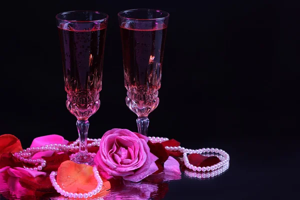 Composition with pink  wine in glasses, bottle  and  roses isolated on black background — Stock Photo, Image