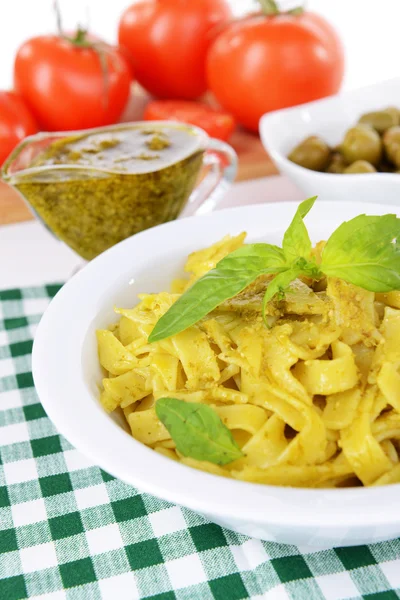 Massa deliciosa com pesto no prato na mesa close-up — Fotografia de Stock