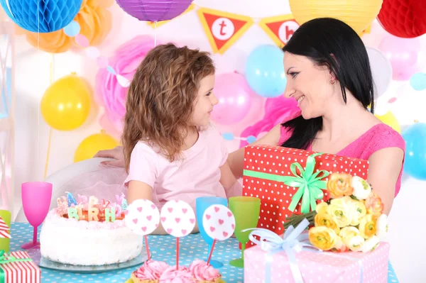 Милая маленькая девочка с мамой празднует свой день рождения — стоковое фото