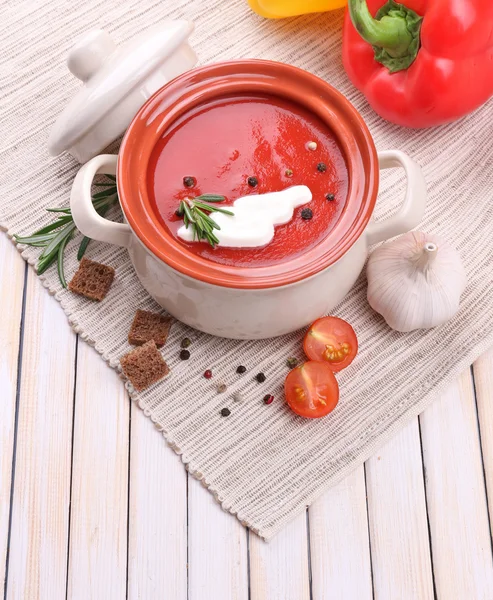 Sabrosa sopa de tomate y verduras en la mesa de madera — Foto de Stock
