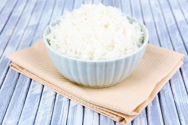 Arroz cozido em tigela no fundo de madeira — Fotografia de Stock