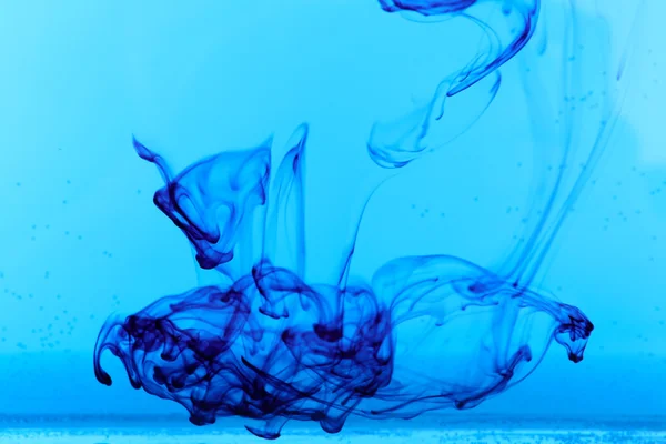 Inkt in water op blauwe ondergrond — Stockfoto
