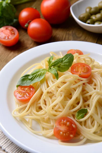 Delicious spaghetti with tomatoes on plate on table close-up Stock Picture