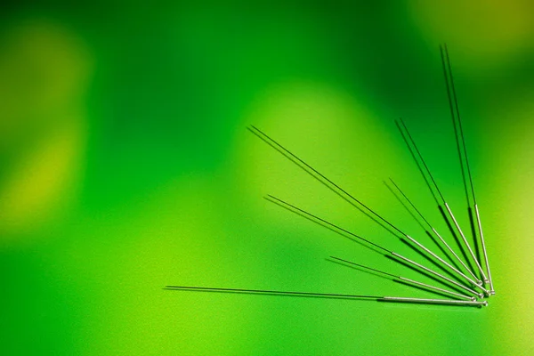 Needles for acupuncture on green background — Stock Photo, Image