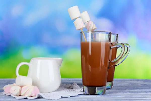 Chocolate quente com marshmallows, no fundo azul — Fotografia de Stock