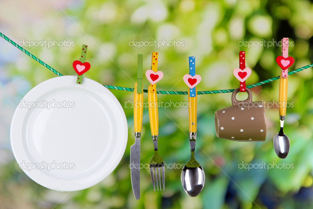 Tableware dried on rope on natural background