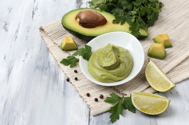 ahşap masa üzerinde kase taze guacamole