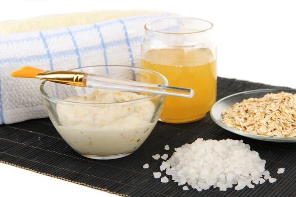 Homemade facial mask with oats and honey on bamboo mat, isolated on white — Stock Photo, Image
