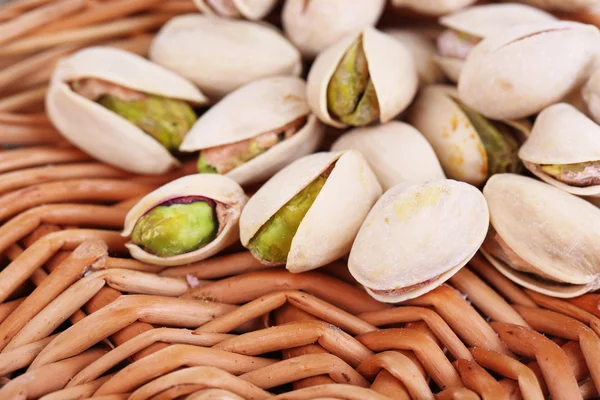Pistachio nuts on wicker stand close up — Stock Photo, Image