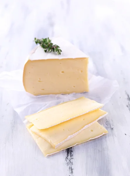 Tasty Camembert cheese with thyme, on wooden table — Stock Photo, Image