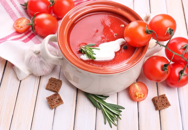 Smakelijke tomatensoep en groenten op houten tafel — Stockfoto