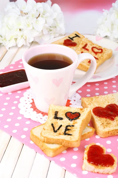 Delicious toast with jam and cup of tea on table close-up — Stock Photo, Image