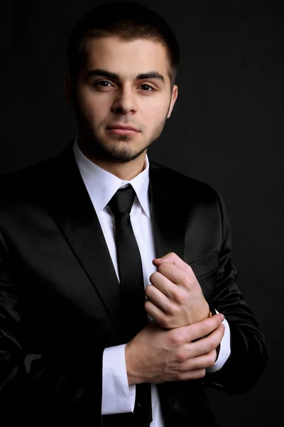 Hombre joven guapo en traje sobre fondo oscuro — Foto de Stock