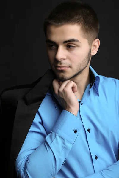 Handsome young man in suit on dark background — Stock Photo, Image