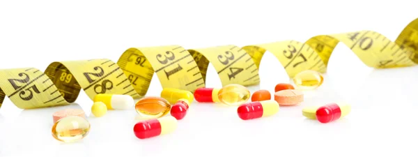 Measuring tape and pills, isolated on white. Dieting concept — Stock Photo, Image