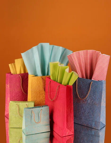 Sacos de compras coloridos, em fundo de cor escura — Fotografia de Stock