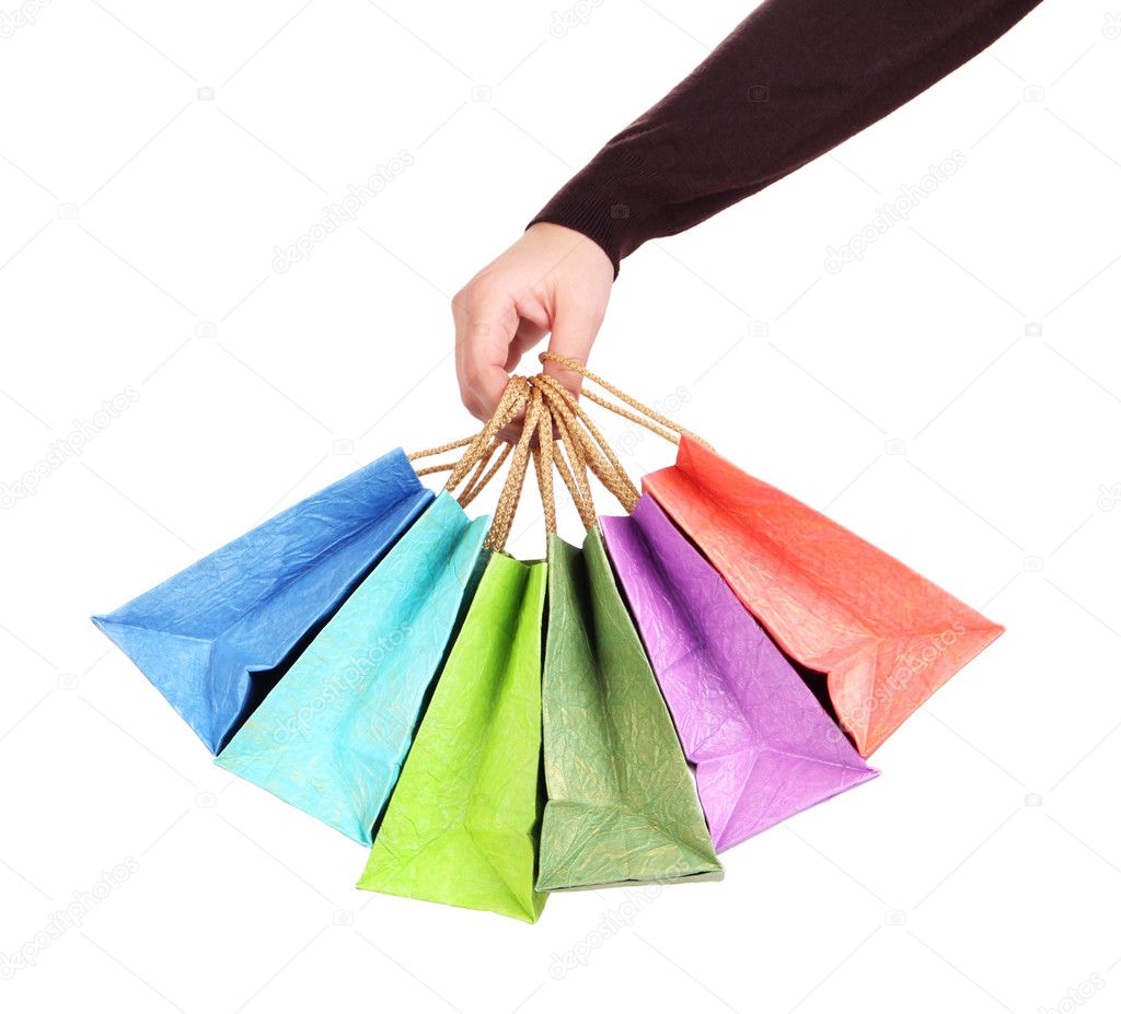 Colorful shopping bags in female hand, isolated on white