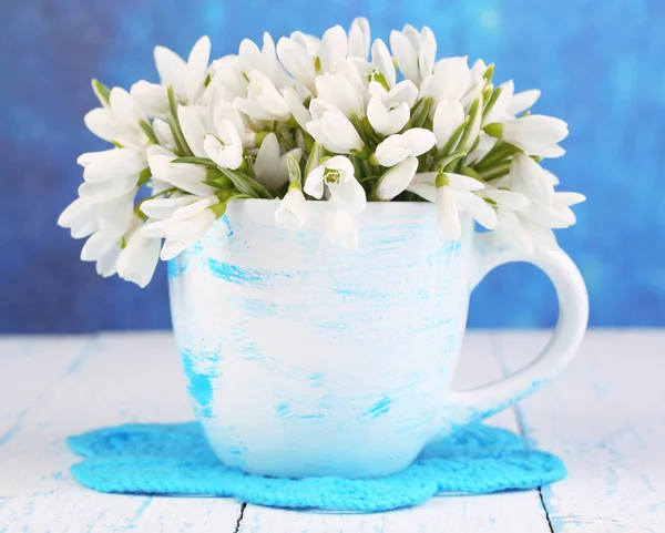 Belas gotas de neve em vaso, na mesa de madeira em fundo brilhante — Fotografia de Stock